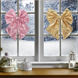 Fiocchi di Natale con paillettes rosa e oro su una finestra invernale innevata