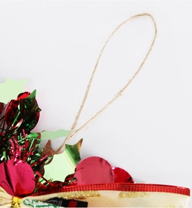 Close-up of Christmas wreath with red green metallic foils and burlap ribbon details