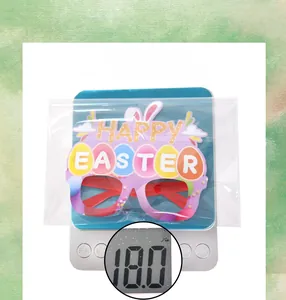 Close-up of Easter party glasses with colorful egg patterns on an electronic weight scale