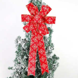 Large red Christmas tree topper bow with gold snowflake prints and elegant ribbons