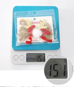 Détail de la pince de Noël bois de cerf à paillettes pesant 15,1g sur une balance