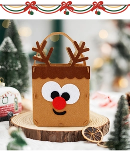 Gros plan d'un sac de Noël en feutre renne marron posé sur un support en bois