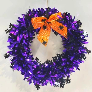 Detail of Halloween wreath with purple tinsel, black ghosts and orange spider web bow