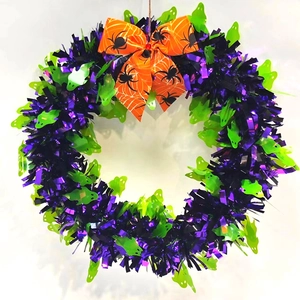 Detail of Halloween wreath with purple tinsel, green ghosts, and orange spider bow