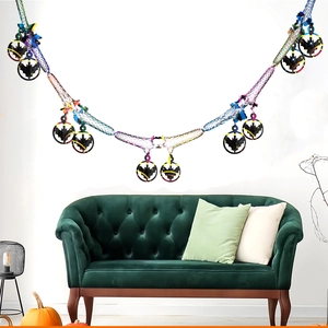 Close-up of Halloween laser bat pendants on a colorful mesh rope above a green sofa