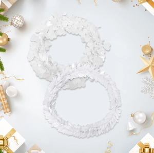 Close-up of two white festive wreaths with heart leaves and fine needles for DIY decor
