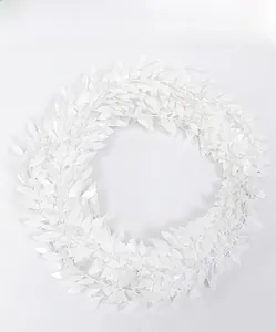 Close-up of white artificial leaf wreath showing intricate layered foliage detail