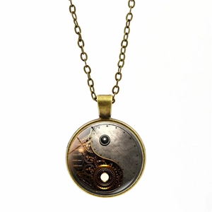 Detail of steampunk yin yang pendant with intricate gears and bronze metal chain