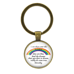 Vintage bronze keychain featuring rainbow design and Wizard of Oz lyrics on white background