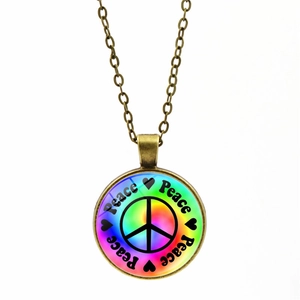 Vue détaillée du pendentif signe de paix en bronze avec fond arc-en-ciel et cœurs