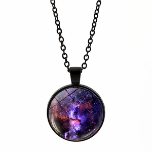 Detail of round cosmic nebula pendant featuring galaxy artwork under domed glass cover