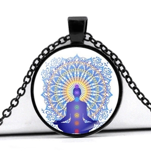 Makroansicht des Mandala-Meditationsanhängers mit bunten Chakra-Symbolen und Silhouette