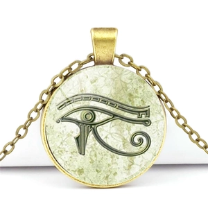 Vintage bronze Eye of Horus necklace with glass cabochon pendant on a white background