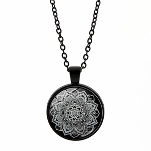 Detailed view of mandala glass pendant with intricate white geometric floral pattern