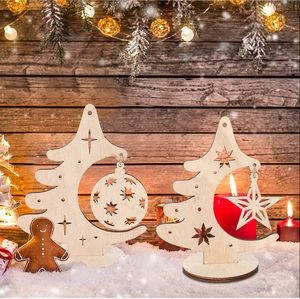 Detail of wooden Christmas tree ornaments with laser-cut star and ball on a snowy base