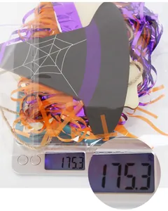 Halloween witch hat decoration package with tassels and ribbons being weighed on a scale
