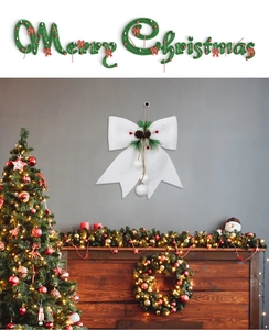 Dettaglio fiocco bianco glitterato con pigne e striscione di Buon Natale decorativo
