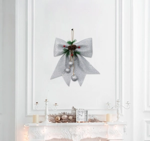 Dettaglio fiocco glitter argento con pigne, bacche e palline d'argento pendenti