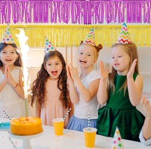 Layered purple and gold fringe curtain backdrop for festive birthday party decorations