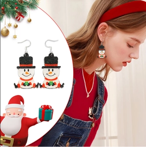 Close-up of glitter snowman earrings with hat and red scarf for Christmas party wear