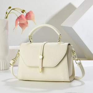 Structured cream leather handbag with gold metal lock and versatile crossbody strap