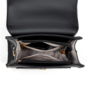 Internal view of black leather bag showing multiple compartments and chevron lining