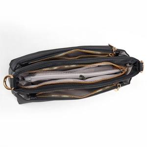 Top view of black nylon crossbody bag showing three zipper compartments and gold hardware
