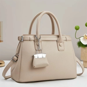 Detail of lychee pattern leather handbag with silver hardware and mini bag charm