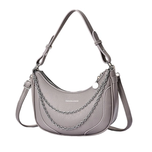 Grey crescent saddle bag with pebble leather texture and decorative silver chain