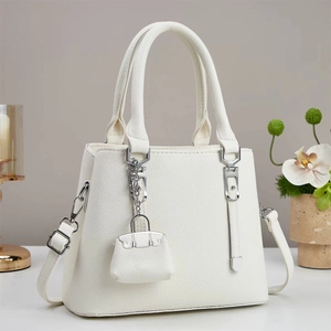 Minimalist beige pebble leather tote bag with silver hardware and orchid decor