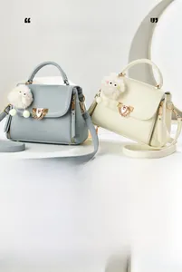 Detail of lychee textured leather mini bags with metal buckle and plush charm decoration