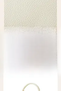 Detailed macro view showing the premium lychee pattern texture on the white leather bag