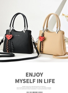 Close-up of lychee grain leather handbags with heart pendants and round handles