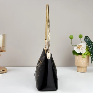 Close-up of black crocodile pattern leather bag with elegant gold chain handle