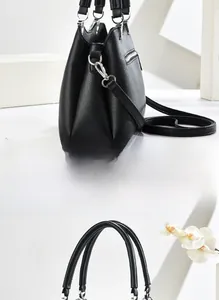 Detail view of black lychee grain leather tote with silver hardware and zipper pocket