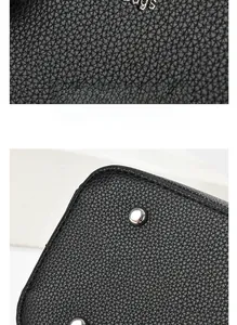 Close-up detail of black lychee grain leather texture and silver metal rivets on the bag