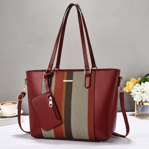 Détail du sac cabas bicolore avec rayures verticales et boucles en métal doré