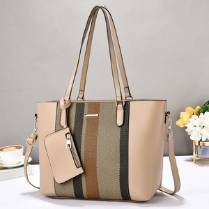 Détail d'un sac cabas beige avec rayures contrastées et petite pochette suspendue assortie
