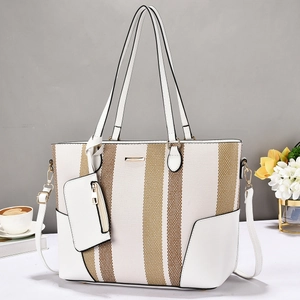 Detailed view of canvas tote bag stitching with brown stripes and white faux leather trim