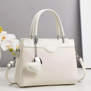 Close-up of white lychee pattern leather texture with silver hardware and heart pendant