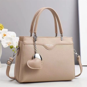 Beige lychee pattern handbag with dual handles and heart pendant in stylish setting