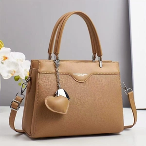 Caramel lychee textured leather handbag with a heart pendant and adjustable shoulder strap