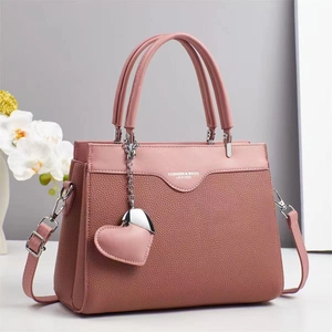 Pink lychee texture leather handbag for women with elegant heart charm and shoulder strap