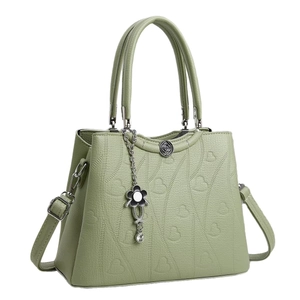 Borsa a mano verde pastello con cuori a rilievo e ciondolo floreale in metallo