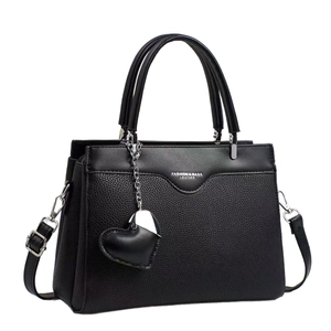 Black pebbled leather tote bag with top handles, heart charm and crossbody strap