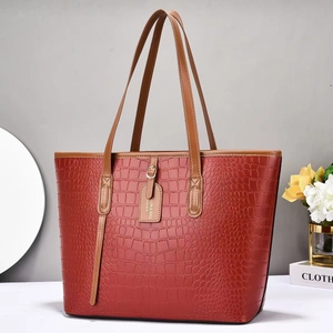 Large brick red tote bag with crocodile texture and long shoulder straps for daily use