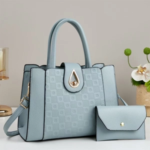 Detail of light blue crossbody bag with checkered pattern and golden teardrop lock