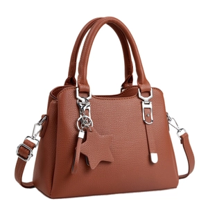 Minimalist caramel brown pebble leather tote bag with star pendant and silver hardware