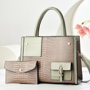 Detail of crocodile embossed two-piece handbag set featuring a tote and matching pouch