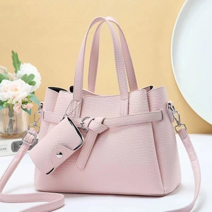 Close-up of pink litchi grain leather handbag with matching mini coin purse and strap